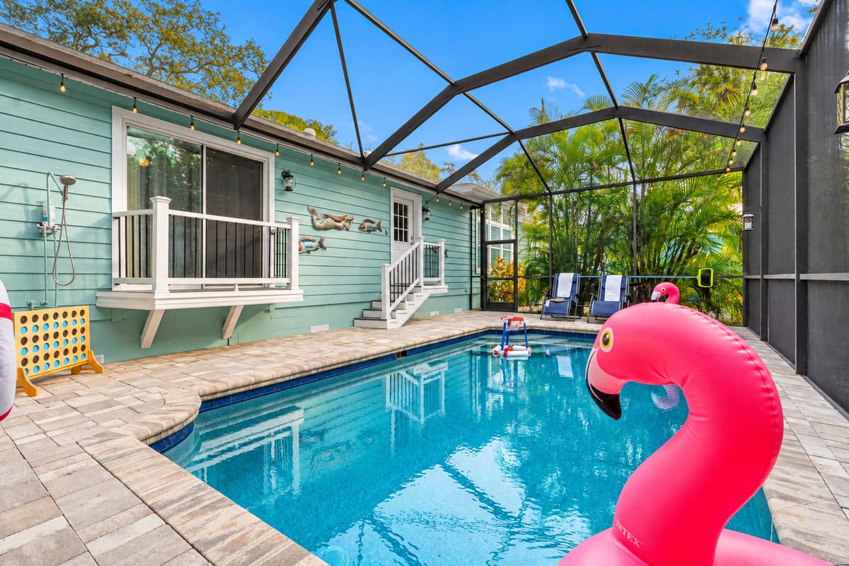 A peaceful backyard escape with a sparkling pool, tall greenery for privacy, and plenty of space for unwinding in the sun.
