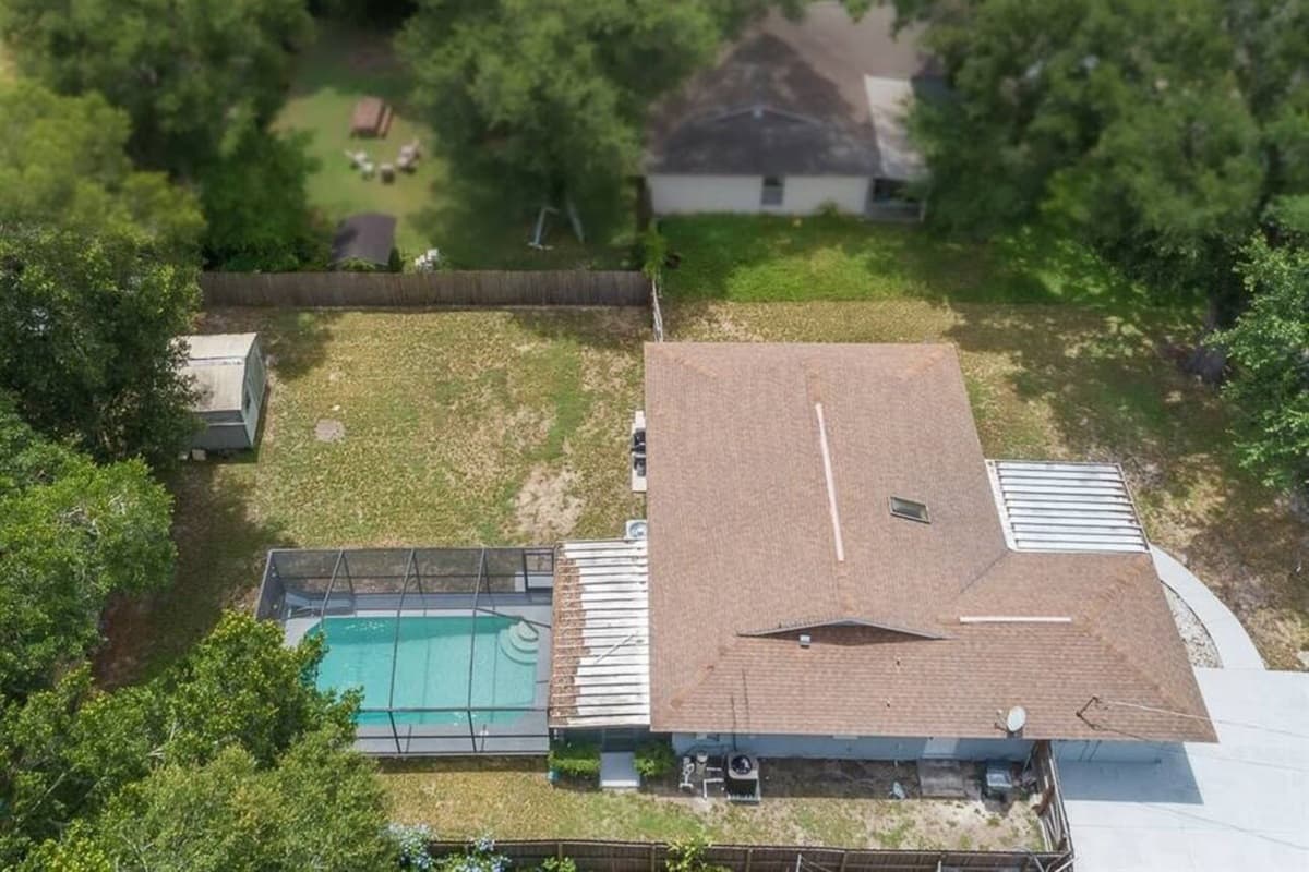 Aerial side profile of the property showcasing the beautiful fully fenced backyard, our immaculate heated pool and spacious driveway. If you are interested in this property, send us an inquiry as soon as possible!