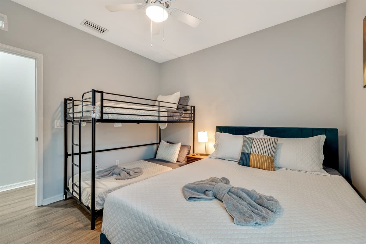 At the heart of the room stands a lavish queen-size bed, a sanctuary of tranquility adorned with soft linens and an abundance of plump pillows, promising a restful night's sleep.