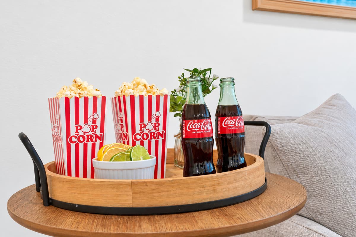 Popcorn and cold sodas are on the menu. Movie night snacks on a tray in the den. The kind of cozy detail that makes a rental feel like home.