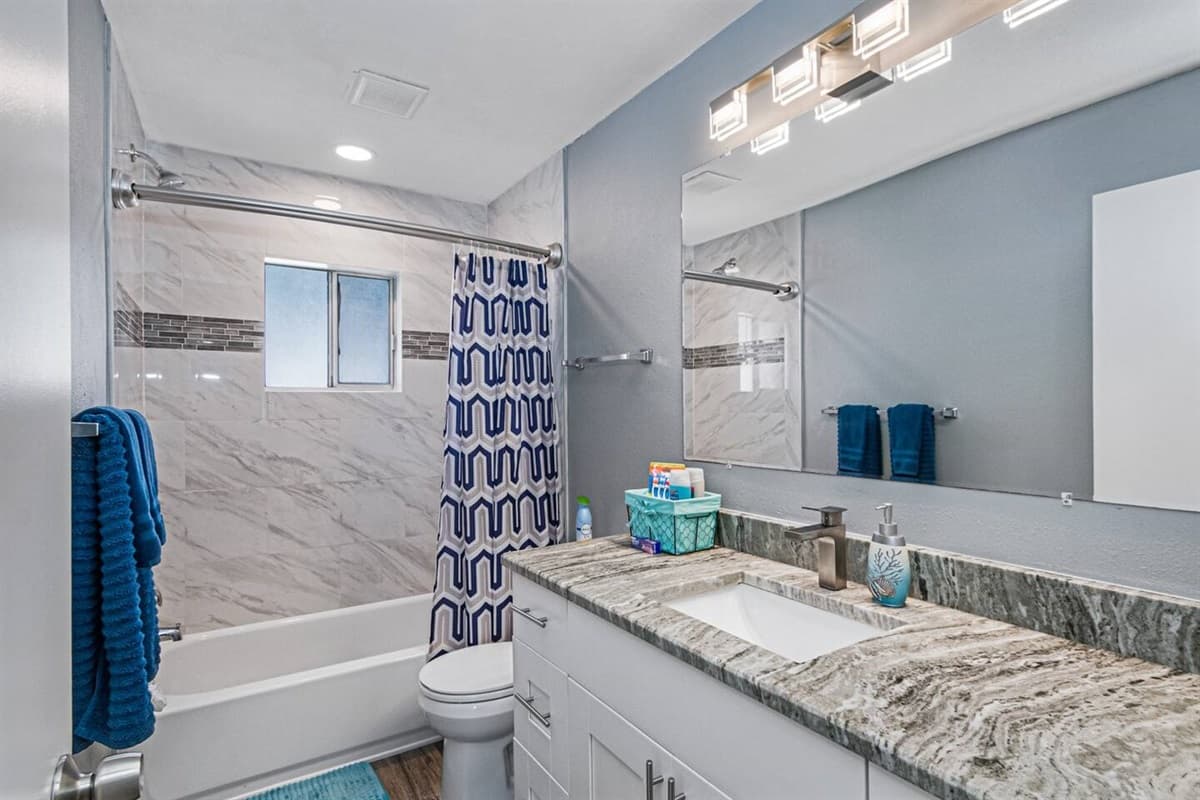 This bathroom has a bathtub, sink, toilet, shower, and wide vanity mirror. Have long baths after long days of fun activities with loved ones! If you like what you see, send us an inquiry!