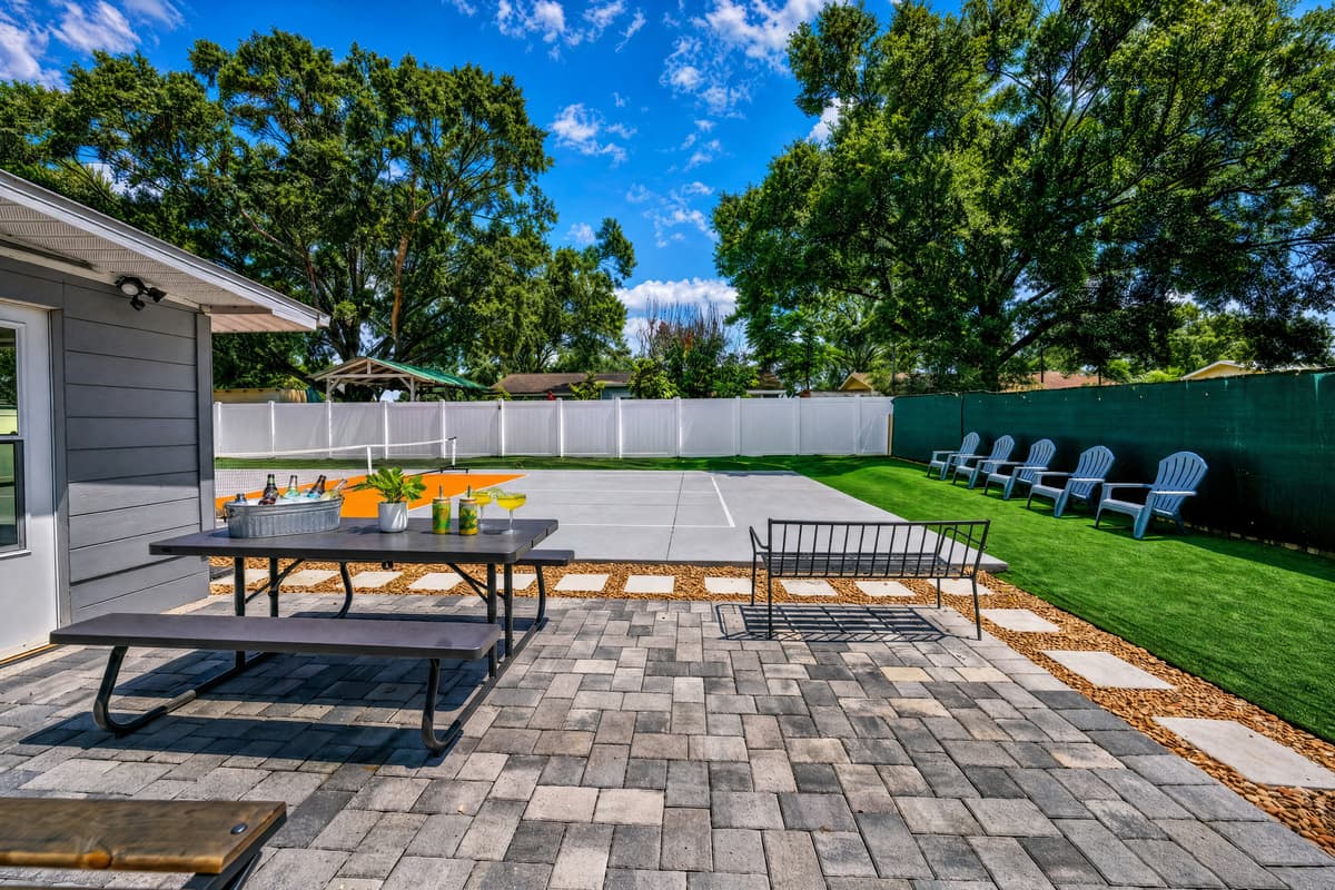 The spacious backyard is designed for fun, featuring a private pickleball court, outdoor seating, and plenty of room to relax in the Florida sunshine.