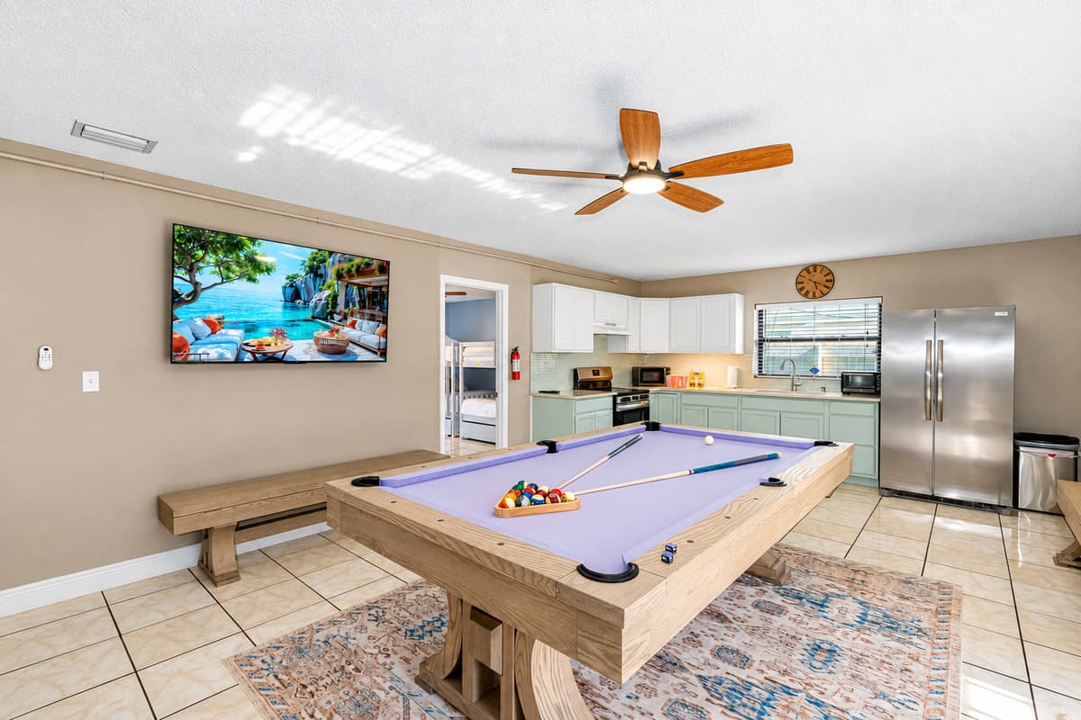 This room is designed for connection—with a dining table that doubles as a ping pong arena, a foosball table for added fun, and a fully stocked kitchen just steps away.