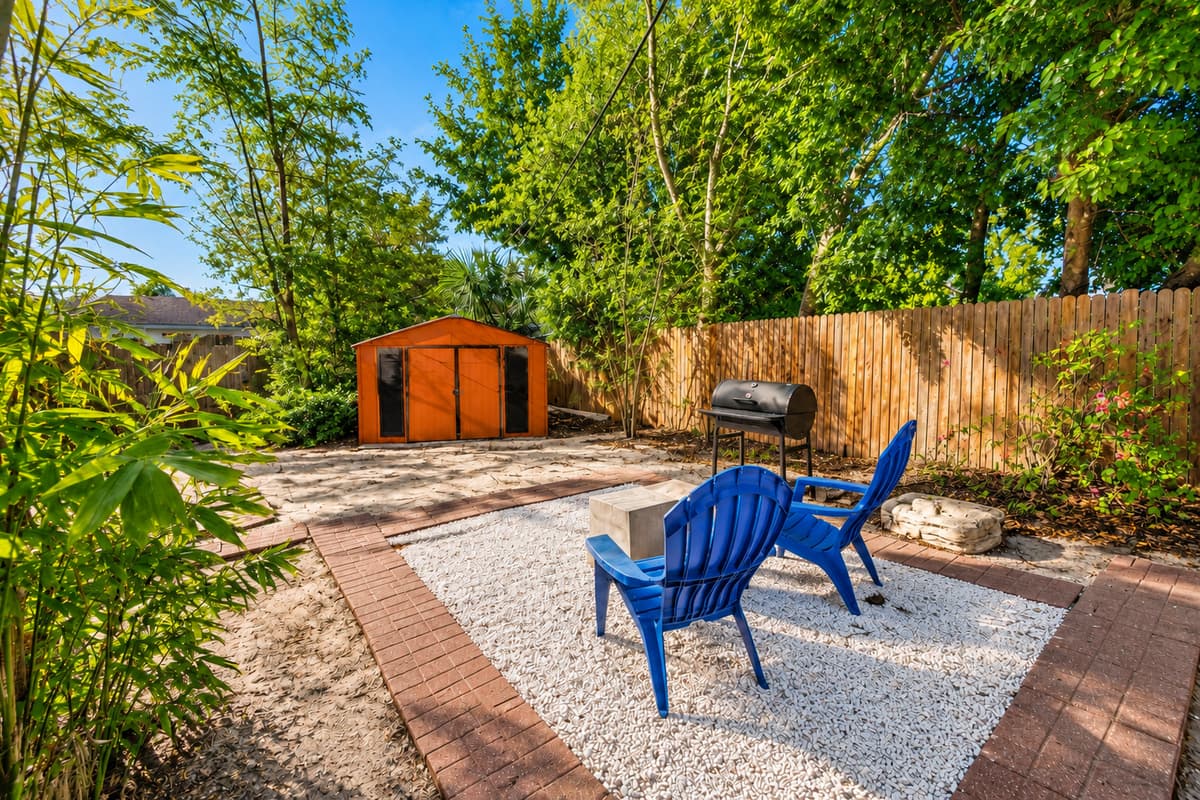 Relaxing backyard corner with cozy seating, mature trees, and a tranquil outdoor atmosphere.