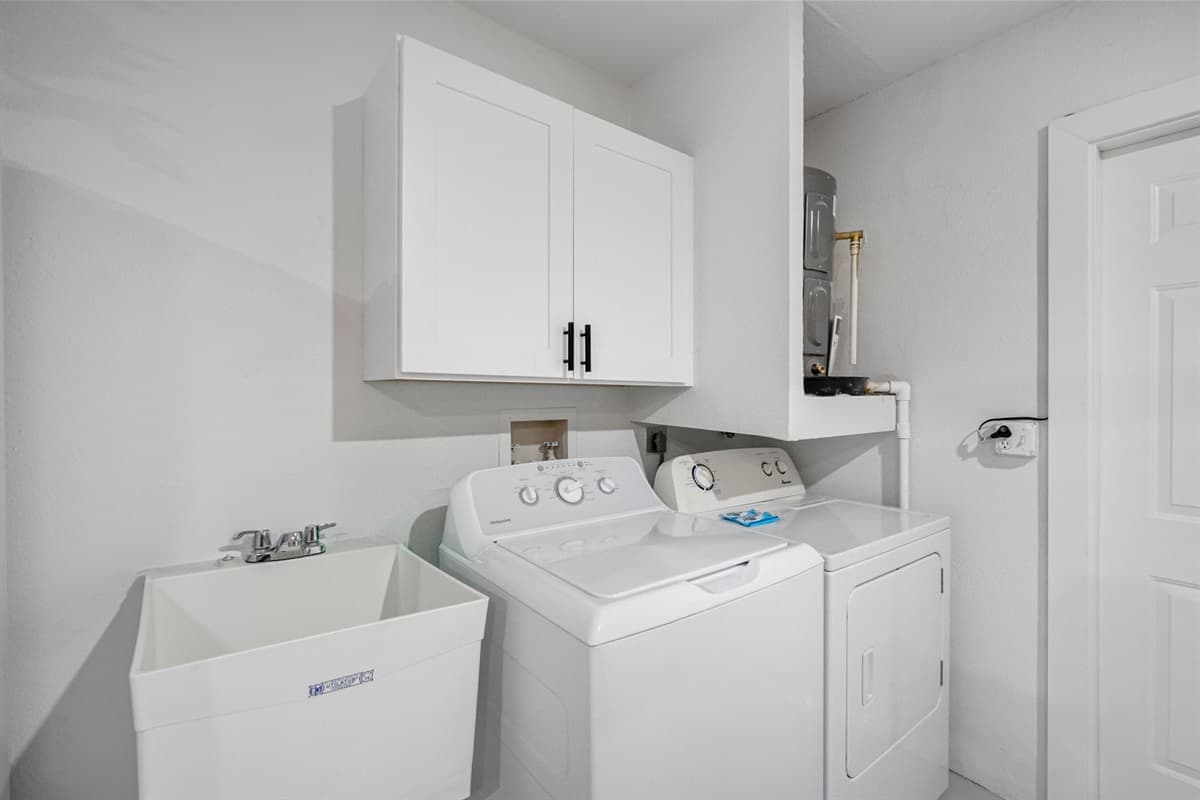 Fully equipped laundry zone with everything you need — washer, dryer, and utility sink to make extended stays effortless