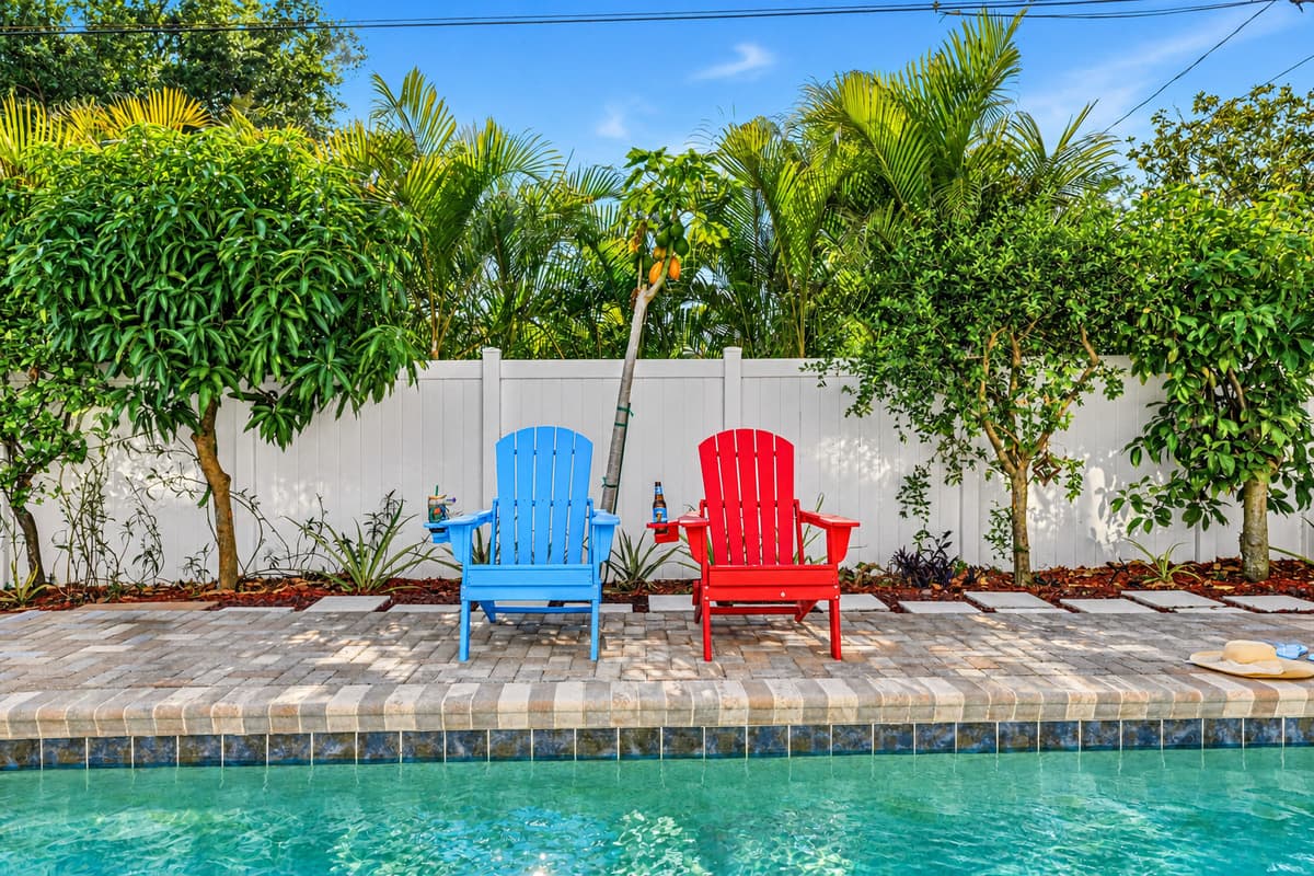 Poolside lounge area with bright chairs and lush greenery—ideal for soaking up the Florida sunshine 