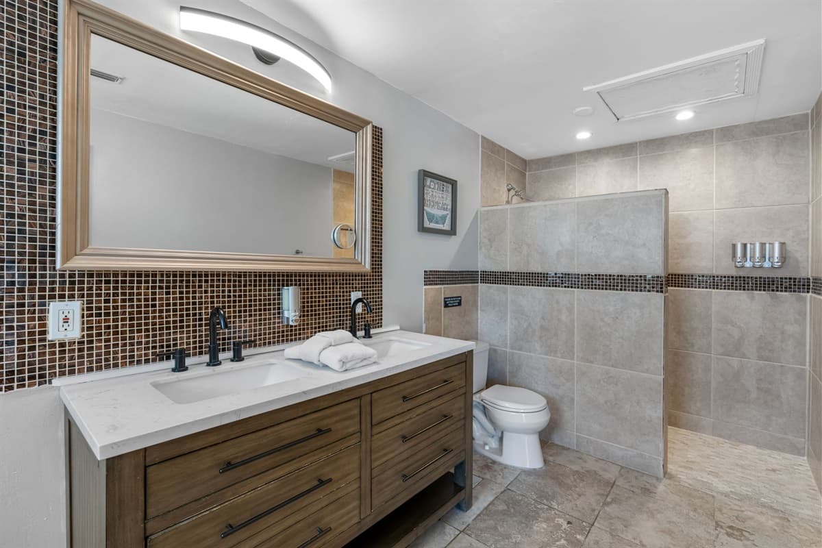 The ensuite bathroom features a double vanity, soaking tub, and warm tile accents.