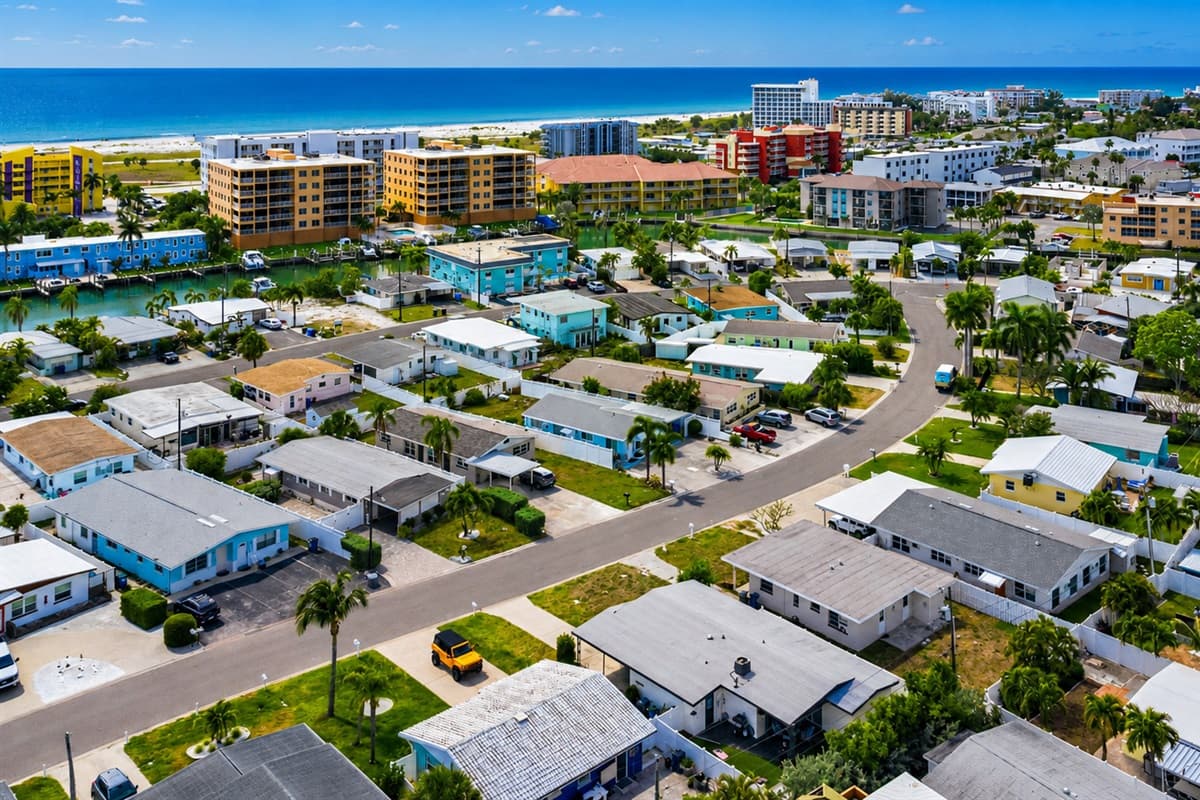 Aerial neighborhood view showcasing the nearby waterways, tropical surroundings, and coastal charm.