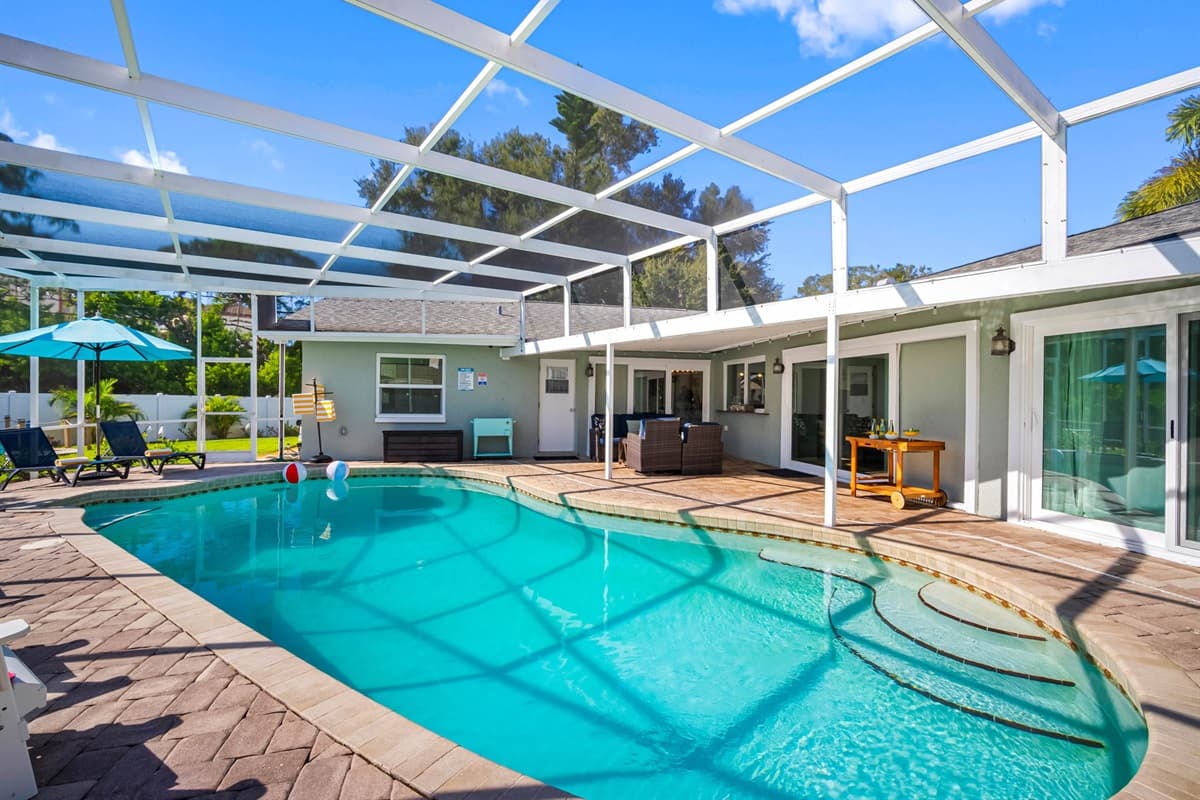Enjoy the outdoors without the bugs! The fully screened lanai features a crystal-clear pool, outdoor seating, and dining space ideal for both morning coffee and sunset cocktails.