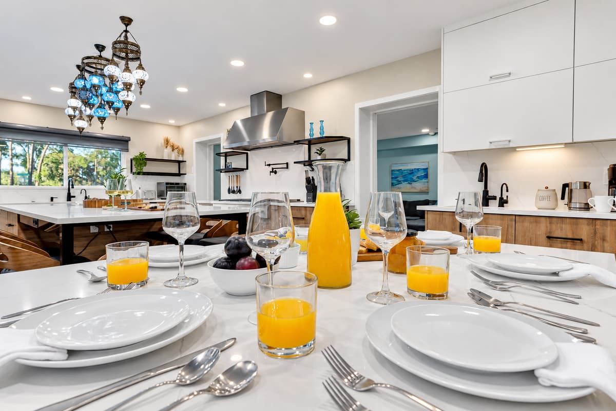 The first morning, before anyone's in the pool. Juice poured, table laid, coffee brewing, and twenty seats waiting under the pendant lights.