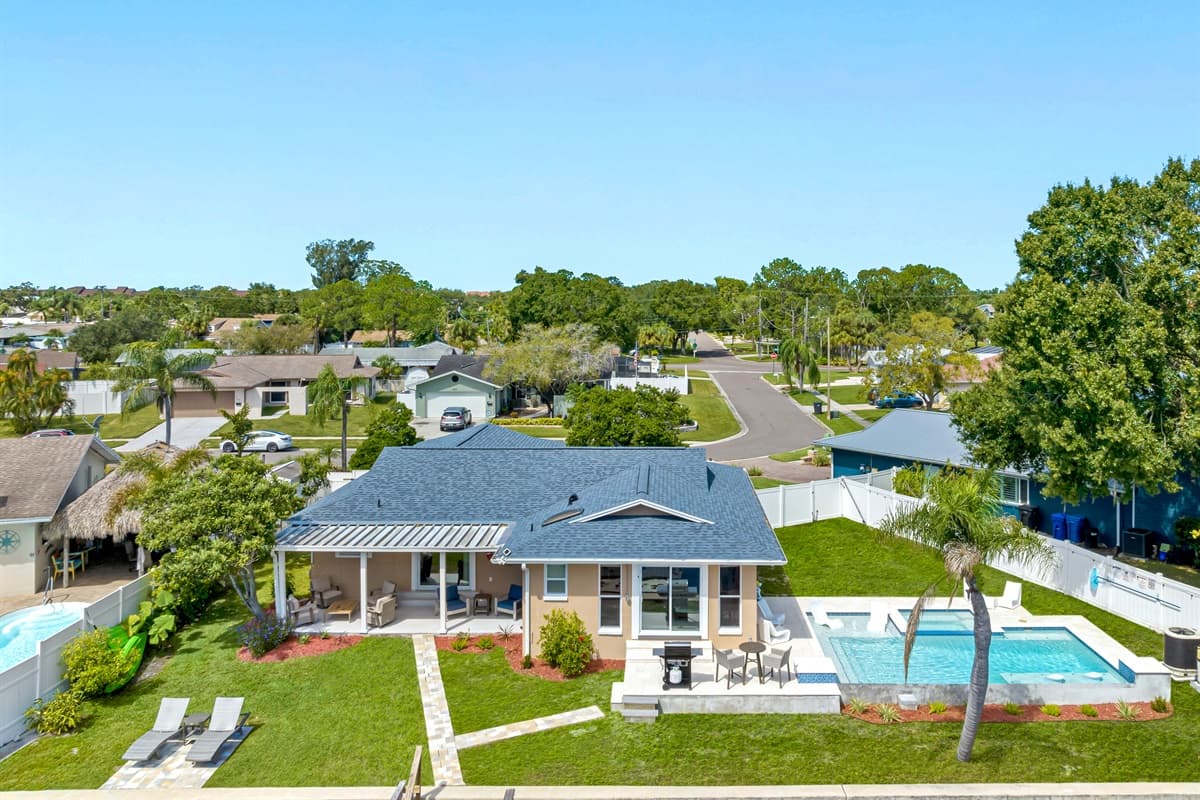 Aerial back view of our beautiful house showcasing our stunning heated pool. The property has some trees and has a fenced backyard. If you are interested in this property, send us an inquiry now!