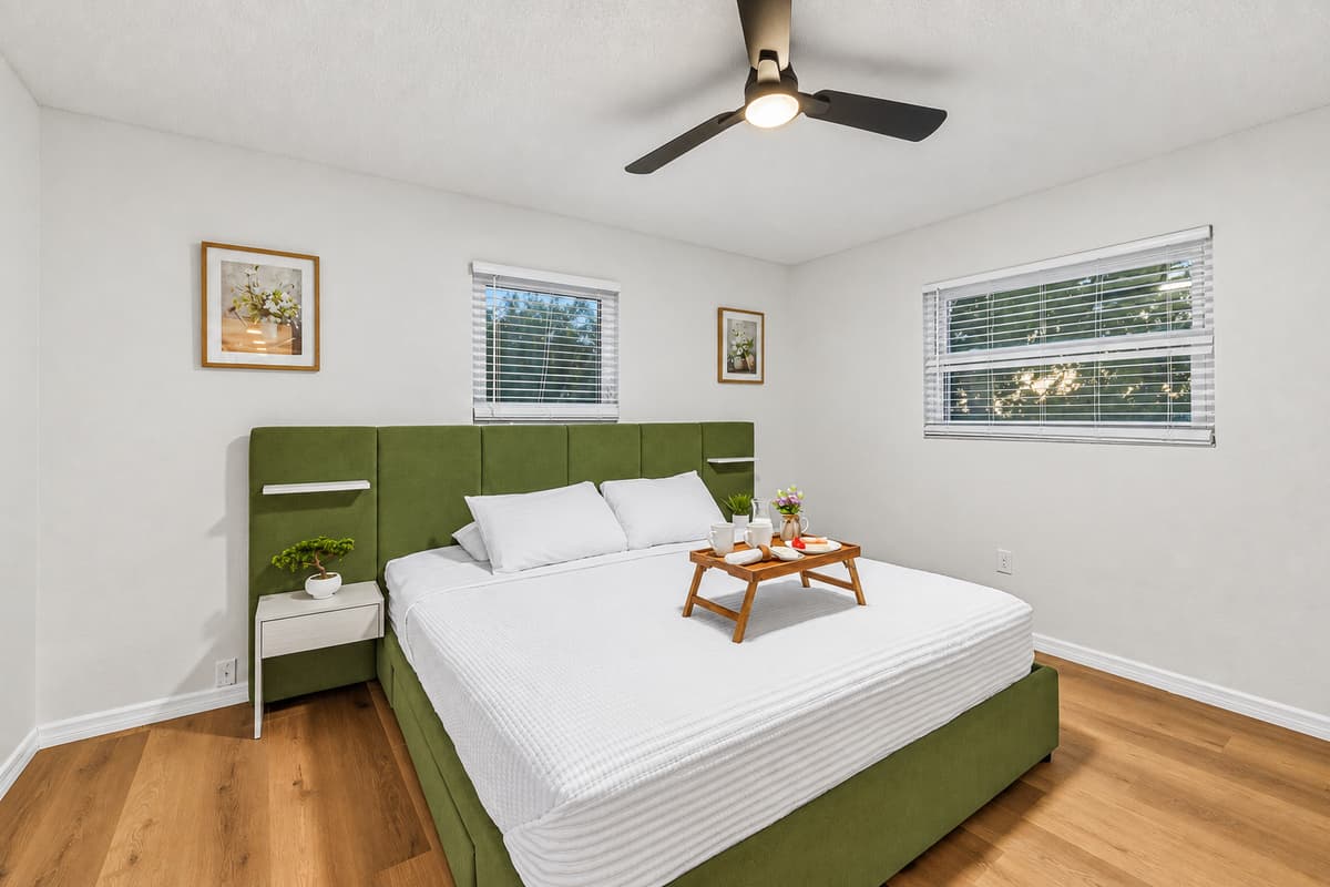 Comfortable king bedroom with clean design, ample natural light, and relaxing ambiance 