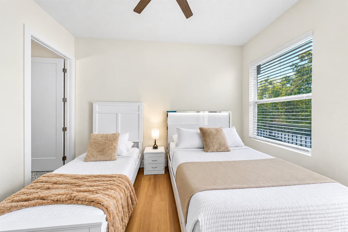 Spacious bedroom with two beds and plenty of natural light.