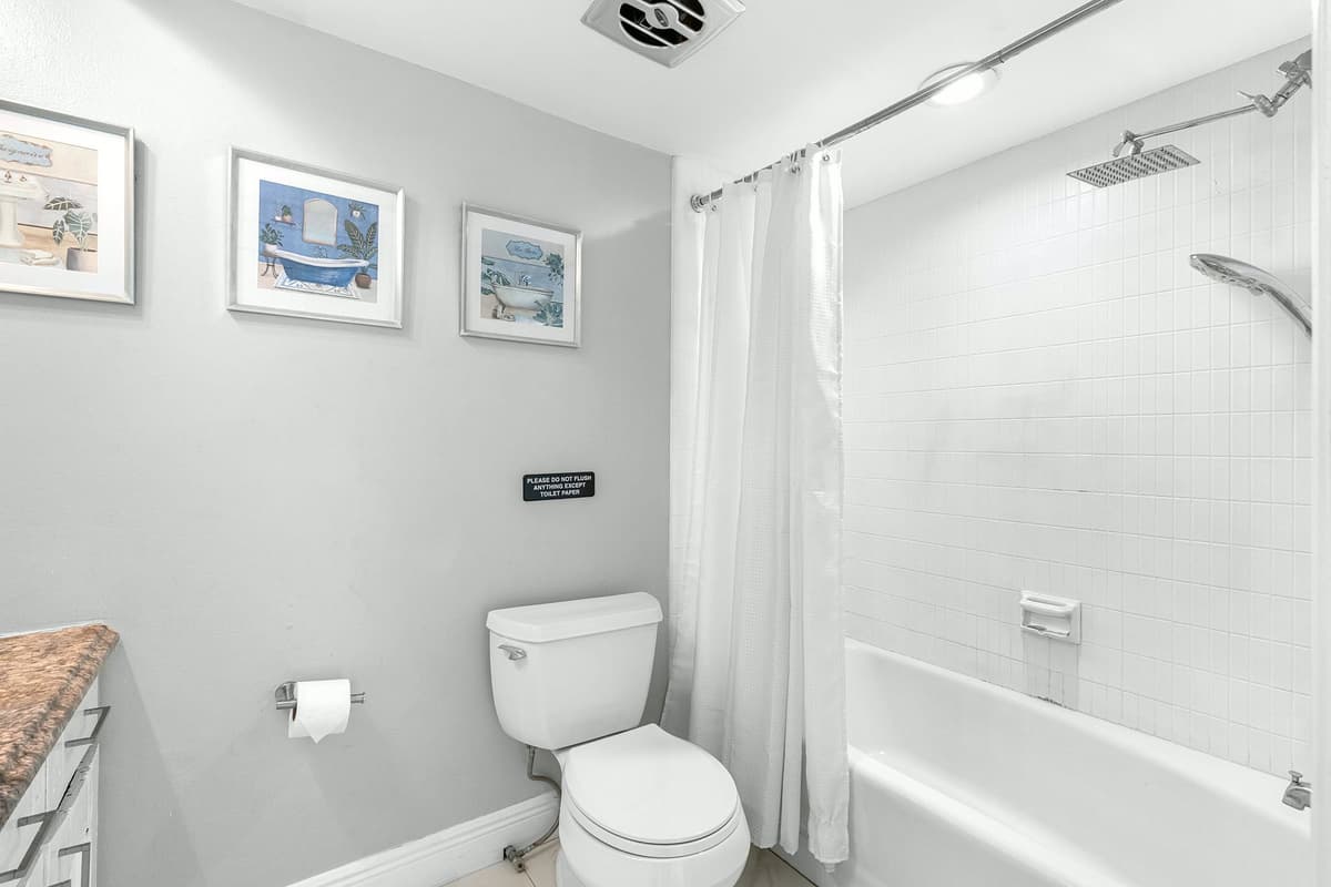 A fresh, modern bathroom featuring a full tub, rainfall showerhead, and soft neutral tones.
