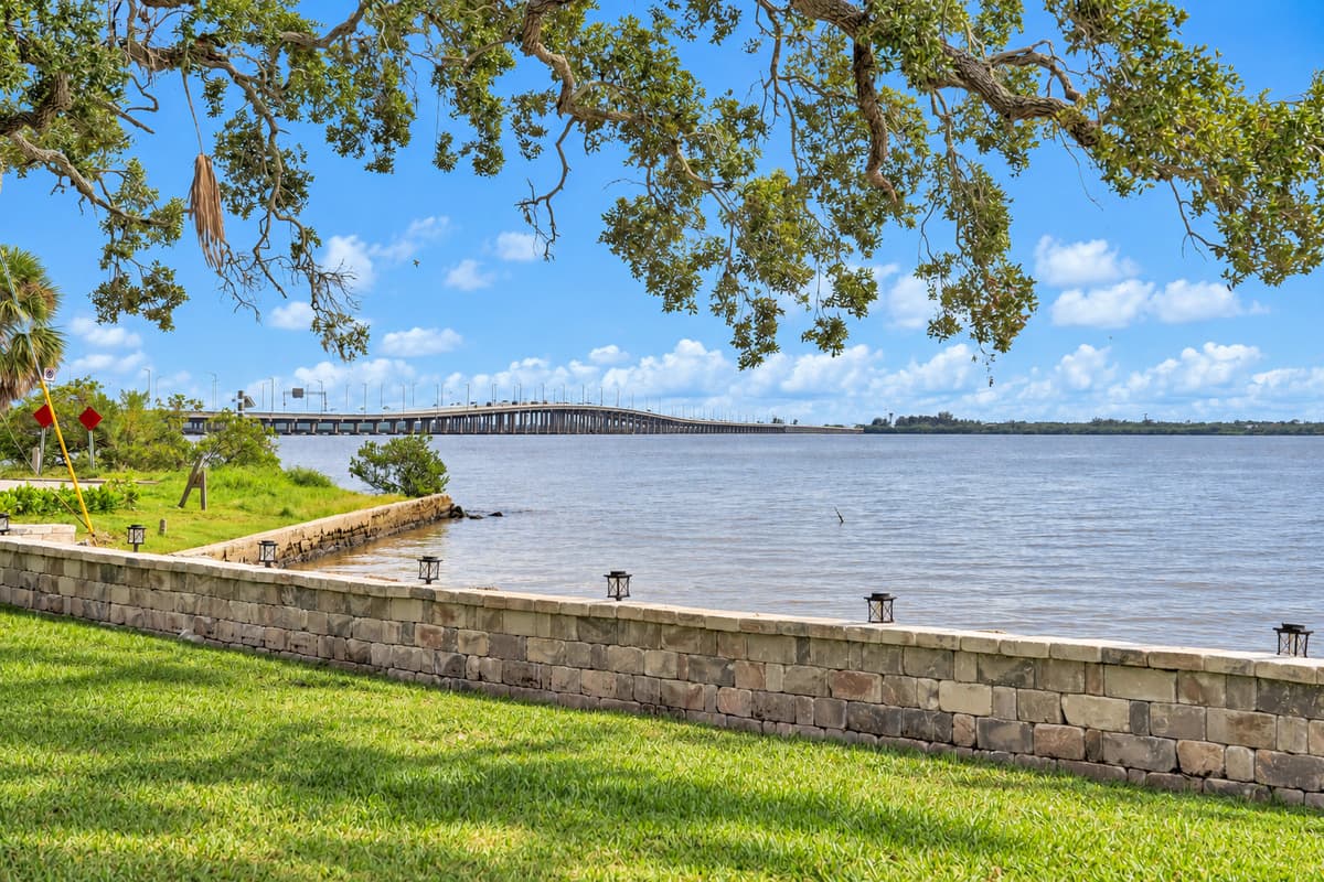 Bay breeze under the oak branches. The stone seawall, calm water and the bridge in the distance. Sit in the shade and let the breeze do its thing.