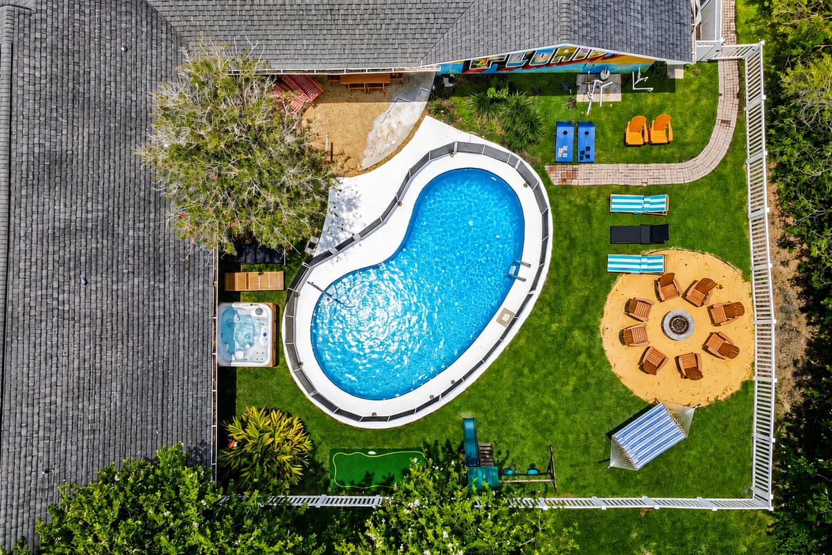 From above: pool, fire pit, playground, and lawn — all fenced, all yours, all at once.