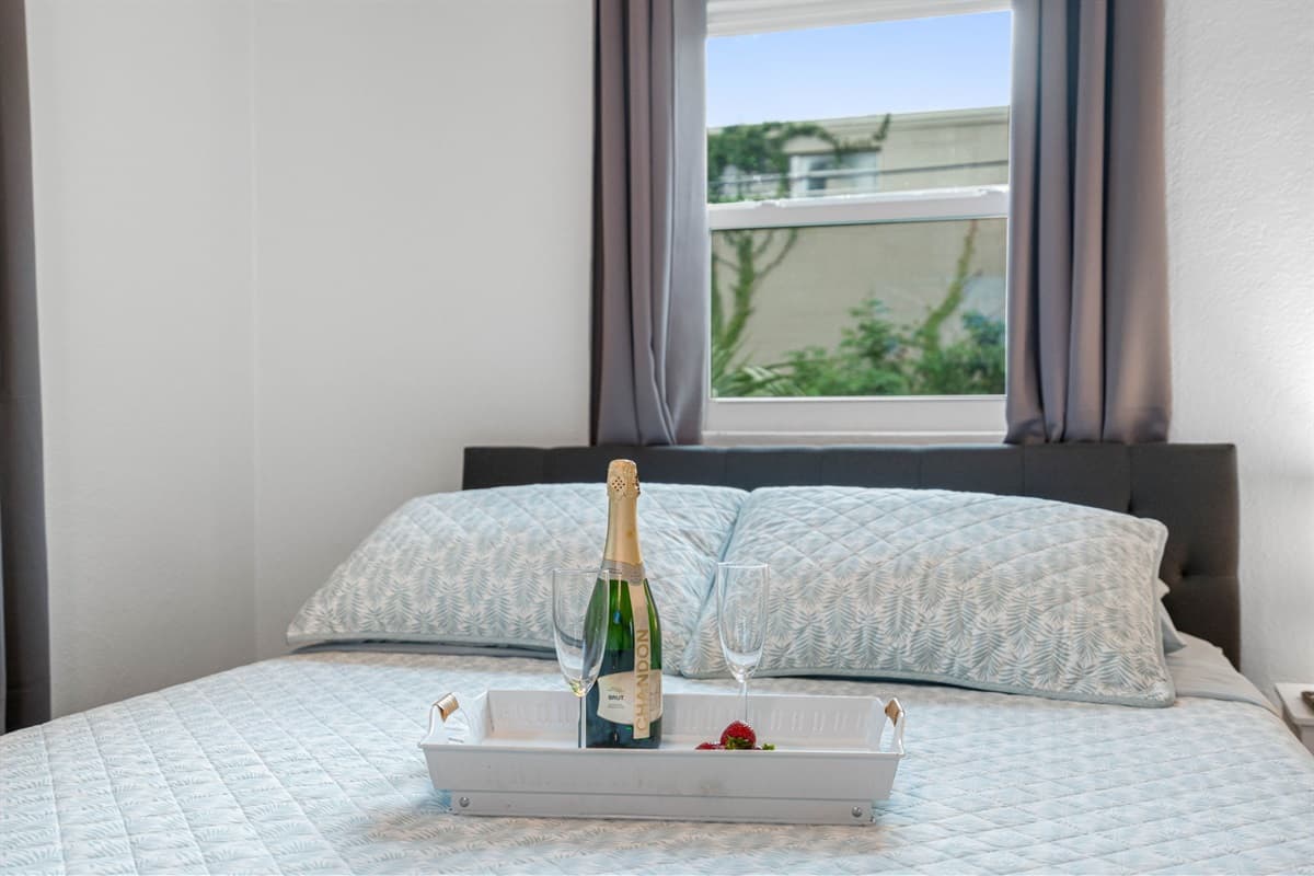 As you enter, you're greeted by the inviting sight of a plush queen-size bed, adorned with soft, high-quality linens and pillows.