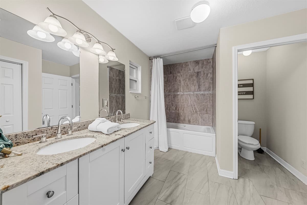 Spacious full bathroom with double vanity, ample counter space, and tub/shower combo.