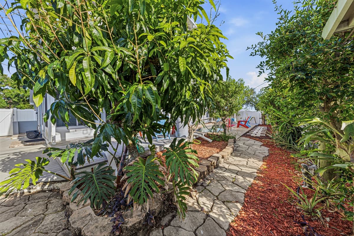 Beautiful garden pathway with lush greenery leading through the backyard—adds charm and tranquility 