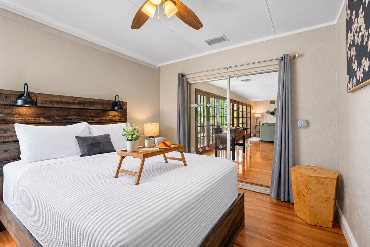 This bedroom offers a warm and inviting retreat with a rustic wood bed frame, soft lighting, and calming neutral tones.
