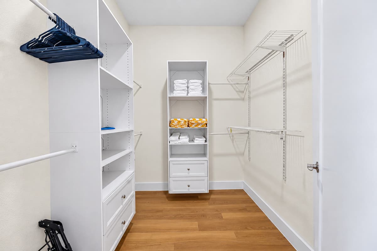 A spacious walk-in closet with hangers and shelving — unpack and make yourself at home.