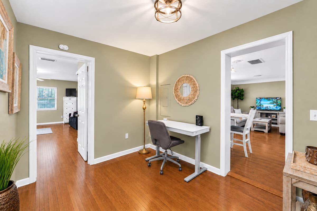 Spacious common area featuring a home office setup and easy access to the dining room.