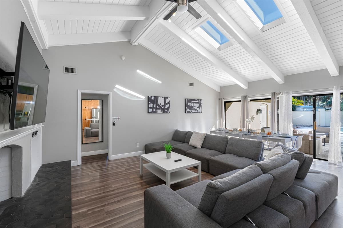 This stylish living room features vaulted ceilings, skylights, and a spacious sectional sofa that invites you to relax in comfort.