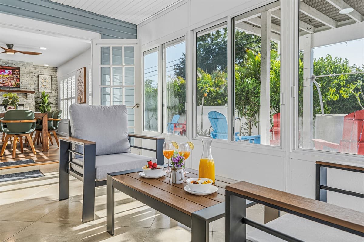 Inviting sunroom with large windows, cozy seating, and natural light throughout 