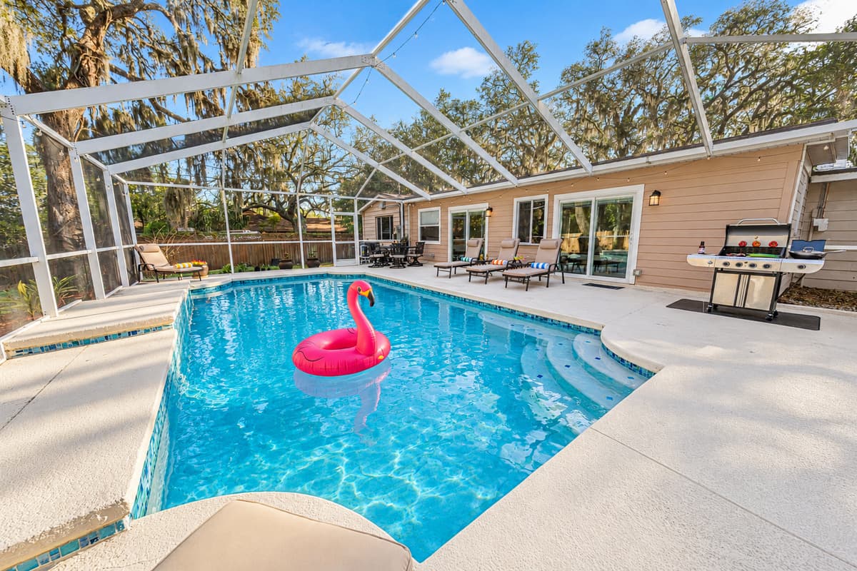Another inviting angle of the pool showcasing the curved design, ample deck space, and comfortable loungers ideal for relaxing between swims.