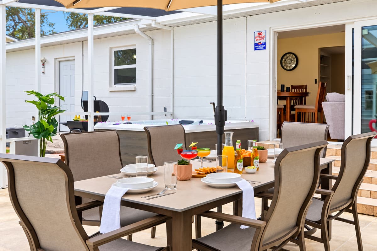 Relax poolside while enjoying outdoor dining with ample seating and a shaded umbrella.