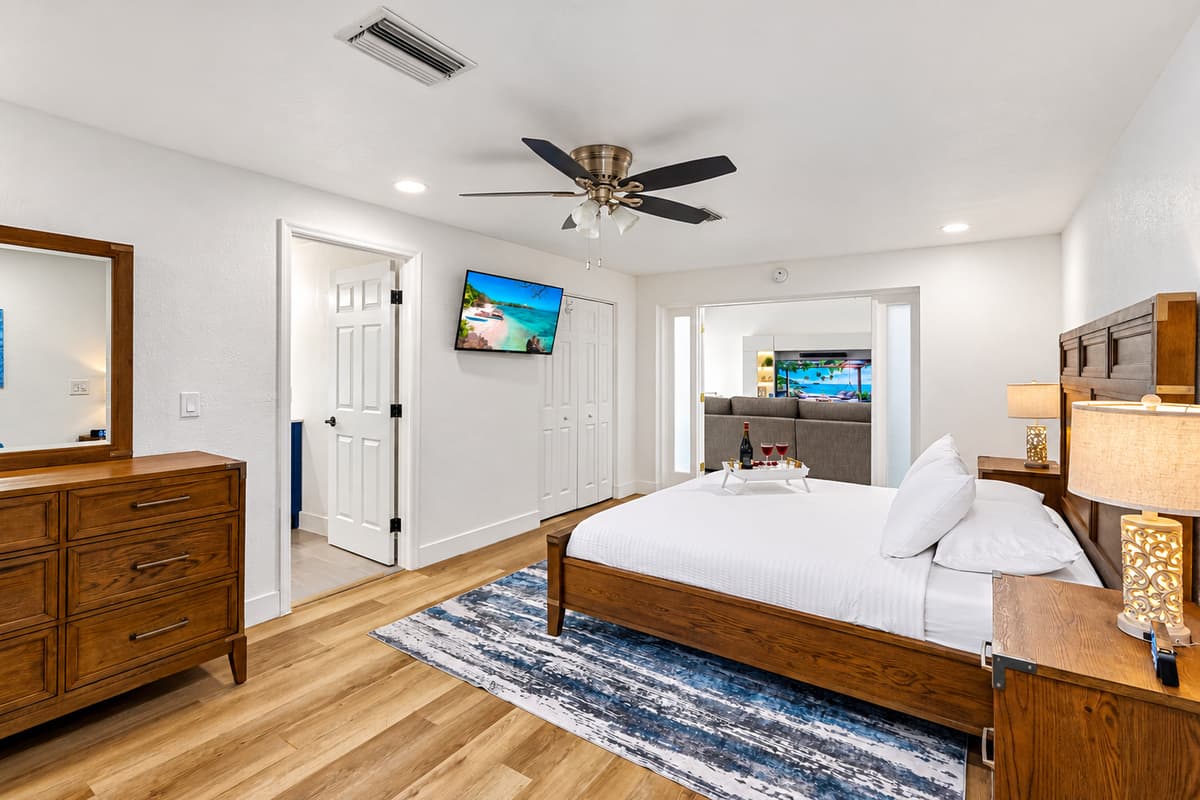 Wake up refreshed in this beautifully appointed master bedroom with rich wood finishes, calming tones, and a mounted Smart TV for lazy mornings.