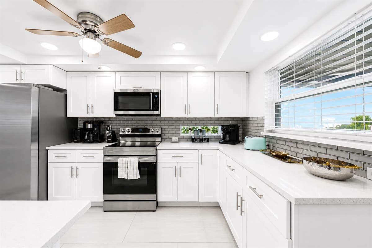Fully equipped kitchen with contemporary finishes, ample prep space, and natural lighting.