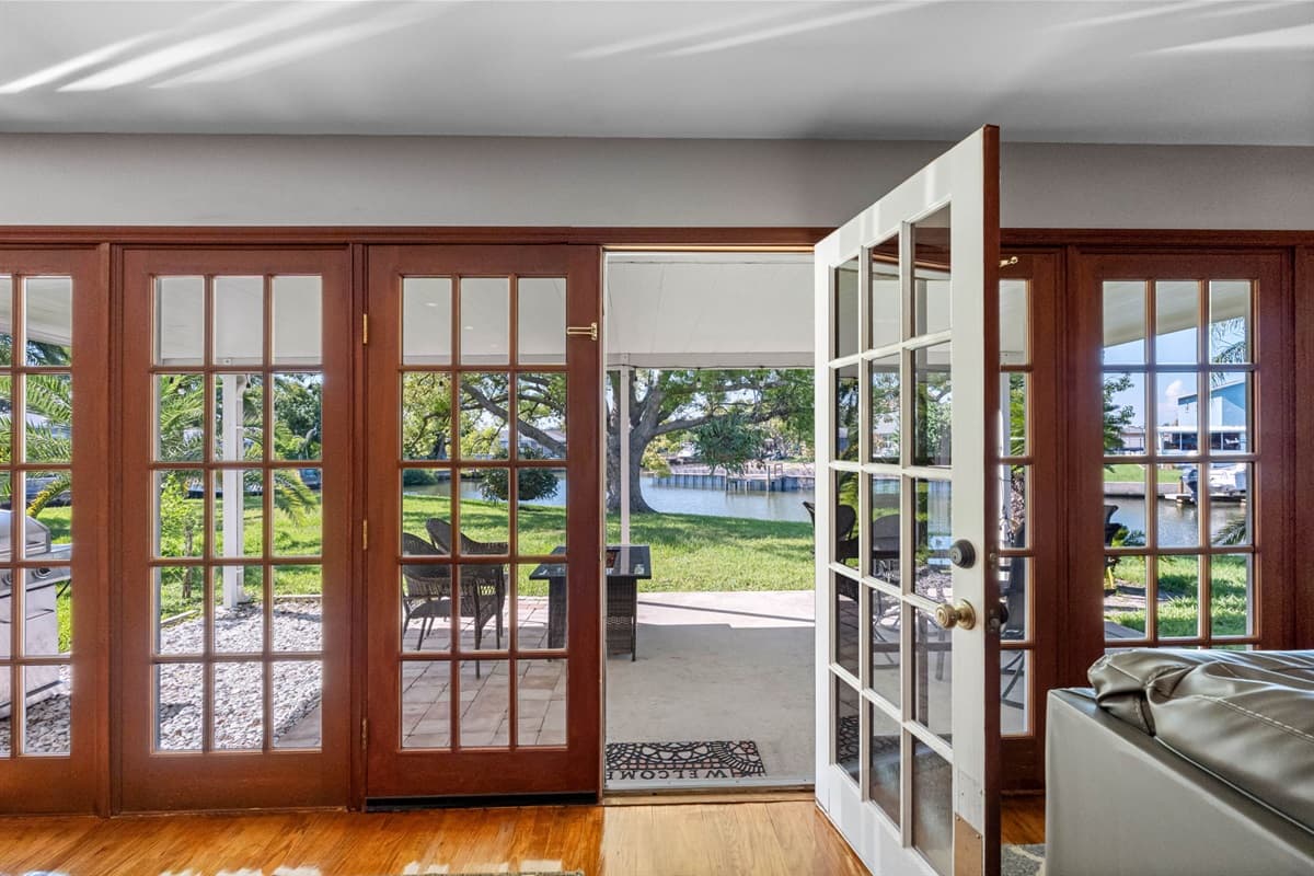 The expansive wall of French doors seamlessly connects the indoors to the outdoors, inviting greenery and sunlight into the heart of the home.