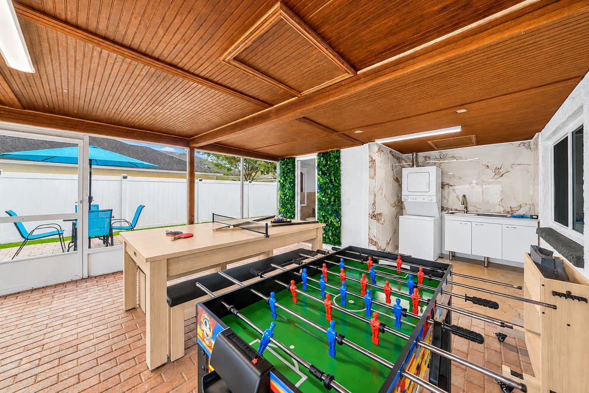 Game-filled patio featuring foosball, pool table fun, and a spacious covered setting perfect for family competitions and group gatherings.