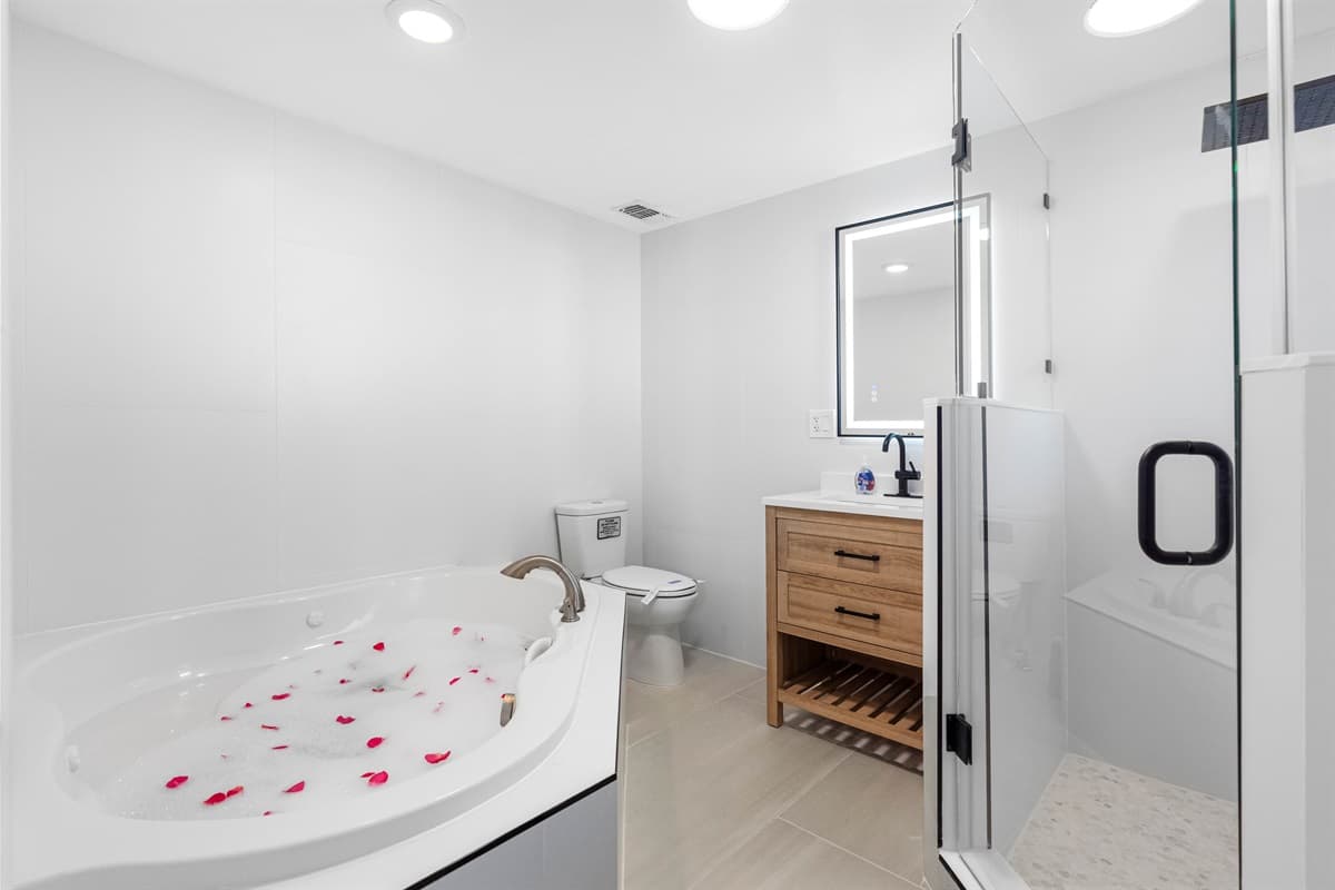 Stunning bathroom with bathtub, sink, toilet and walk in shower.  Enjoy a relaxing bath after a long day of travel from your home to your home away from home.