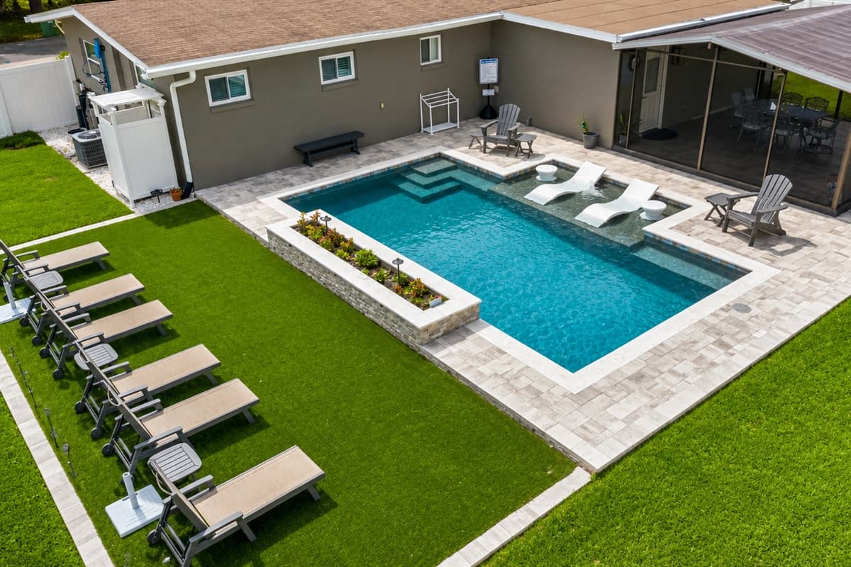 Aerial backyard view showcasing the private pool, spa, lounge chairs, and large outdoor entertaining spaces.