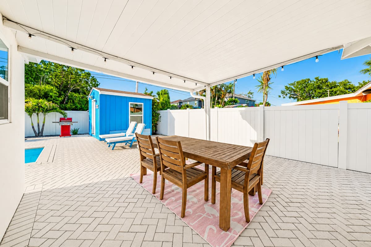 Spacious covered outdoor dining space overlooking the pool deck, perfect for group gatherings and outdoor entertaining.