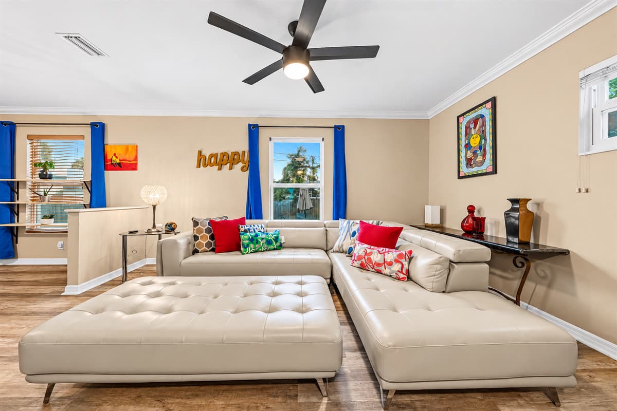 Comfortable living room with plush sectional, large TV, and vibrant accents for a cozy stay.
