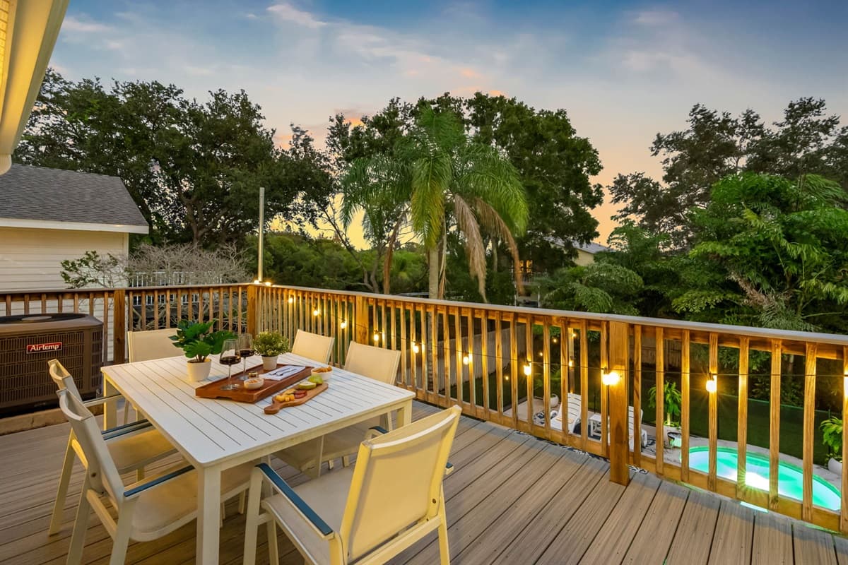 Unwind on this spacious deck surrounded by lush greenery, twinkling lights, and the soft glow of sunset. Perfect for evening drinks, dining al fresco, or simply soaking up the Florida vibes.
