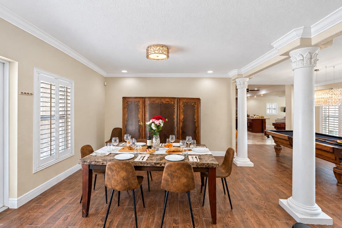 Detailed crown molding and stately columns frame the dining area, adding elegance to every meal enjoyed here.