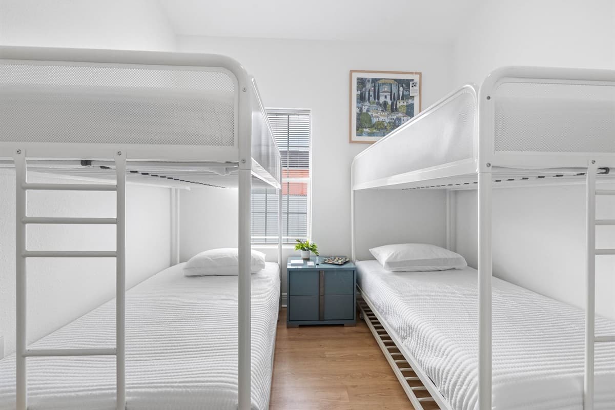 Perfect for families or friends, this airy bunk room offers two sleek bunk beds with plush mattresses, a shared nightstand, and a calm, minimalist aesthetic for restful nights.