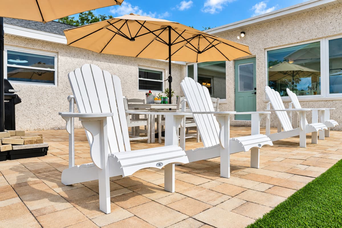 Sun-warmed pavers and Adirondack chairs. A sunny patio lined with Adirondacks, steps from the house. Read, nap or chat for hours with the bay in view.