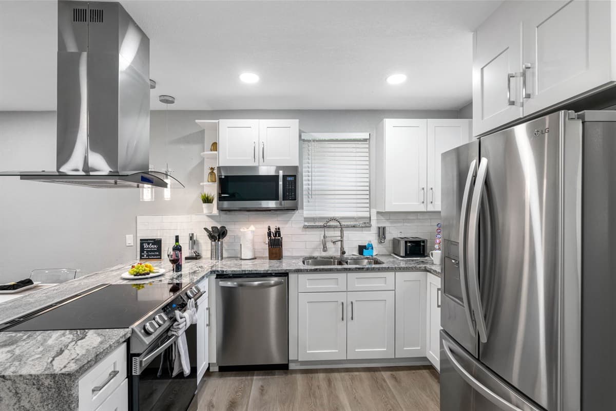 Fully equipped kitchen with stainless steel appliances, granite countertops, and plenty of prep space for cooking meals at home.