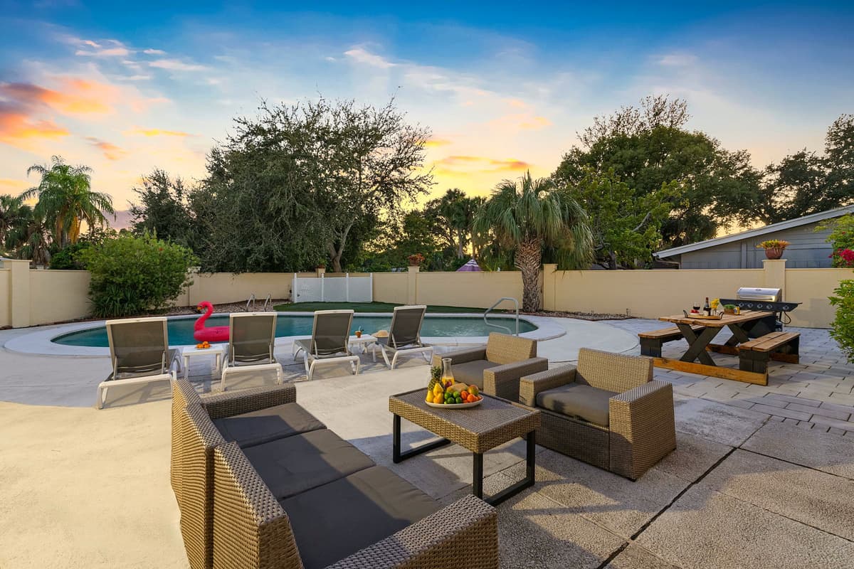 Enjoy golden sunsets by the pool, with plenty of seating, a BBQ grill, and a cozy outdoor dining setup for evening gatherings.