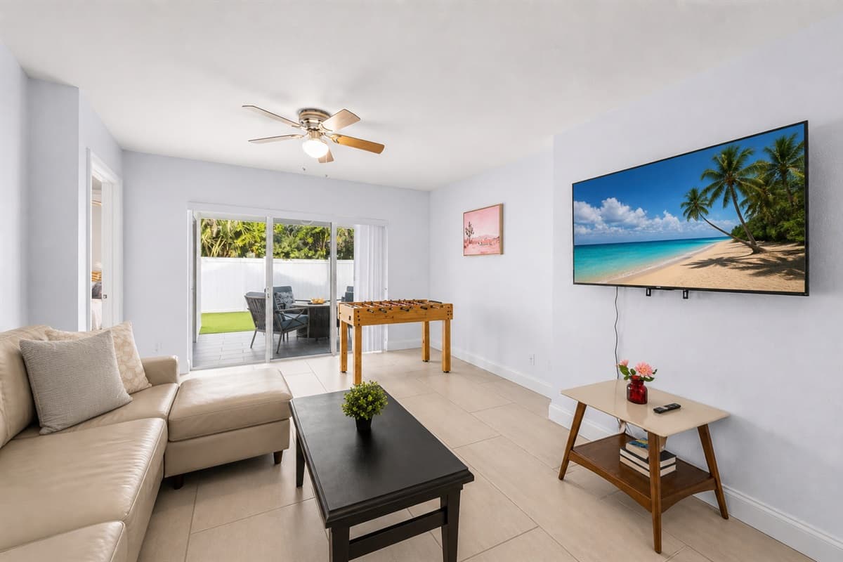Inviting living room with large smart TV, natural light, and direct patio access.