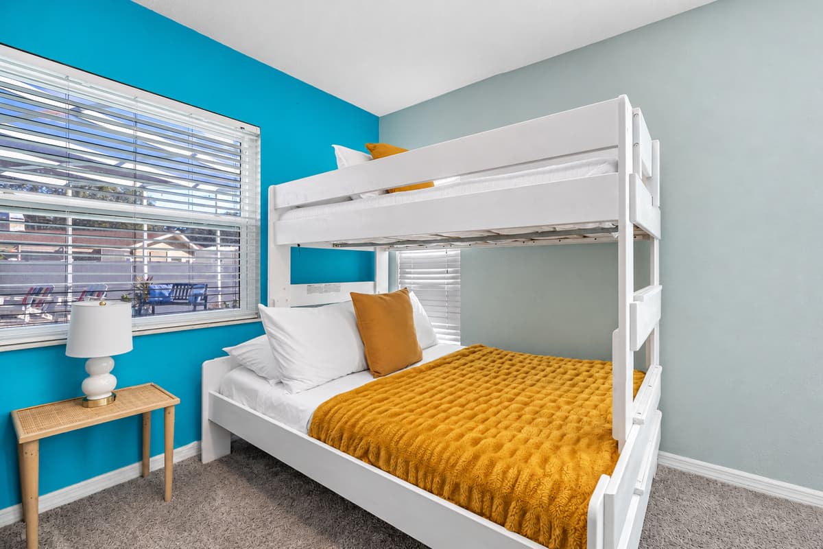Designed with families in mind, this bunk room offers cozy beds and a fun pop of color for younger guests.