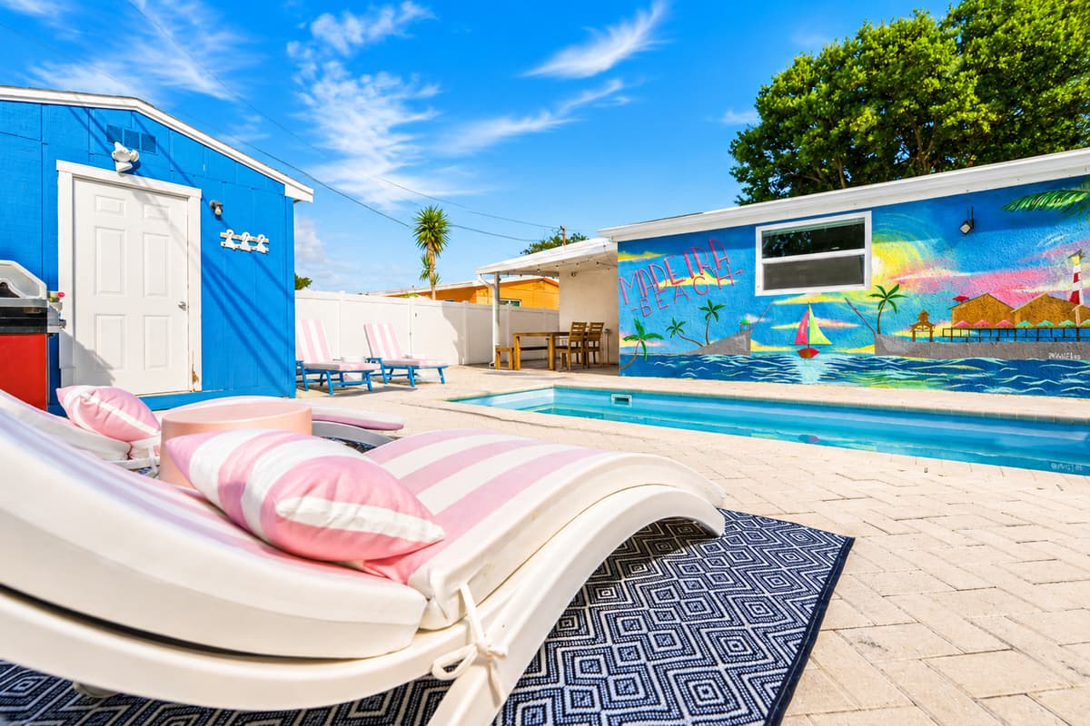 Premium poolside loungers with striped cushions positioned beside the pool for sunbathing and relaxation.