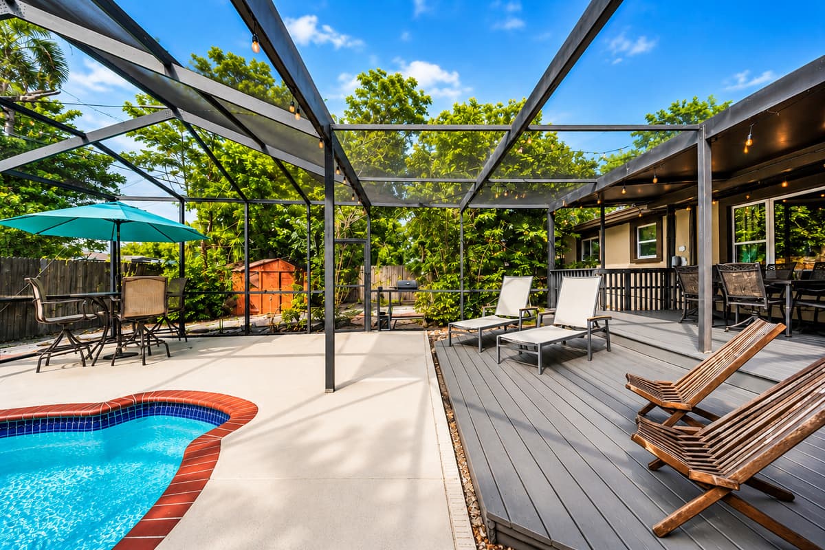 Spacious pool deck featuring comfortable lounge chairs, shaded seating, and beautiful backyard views.