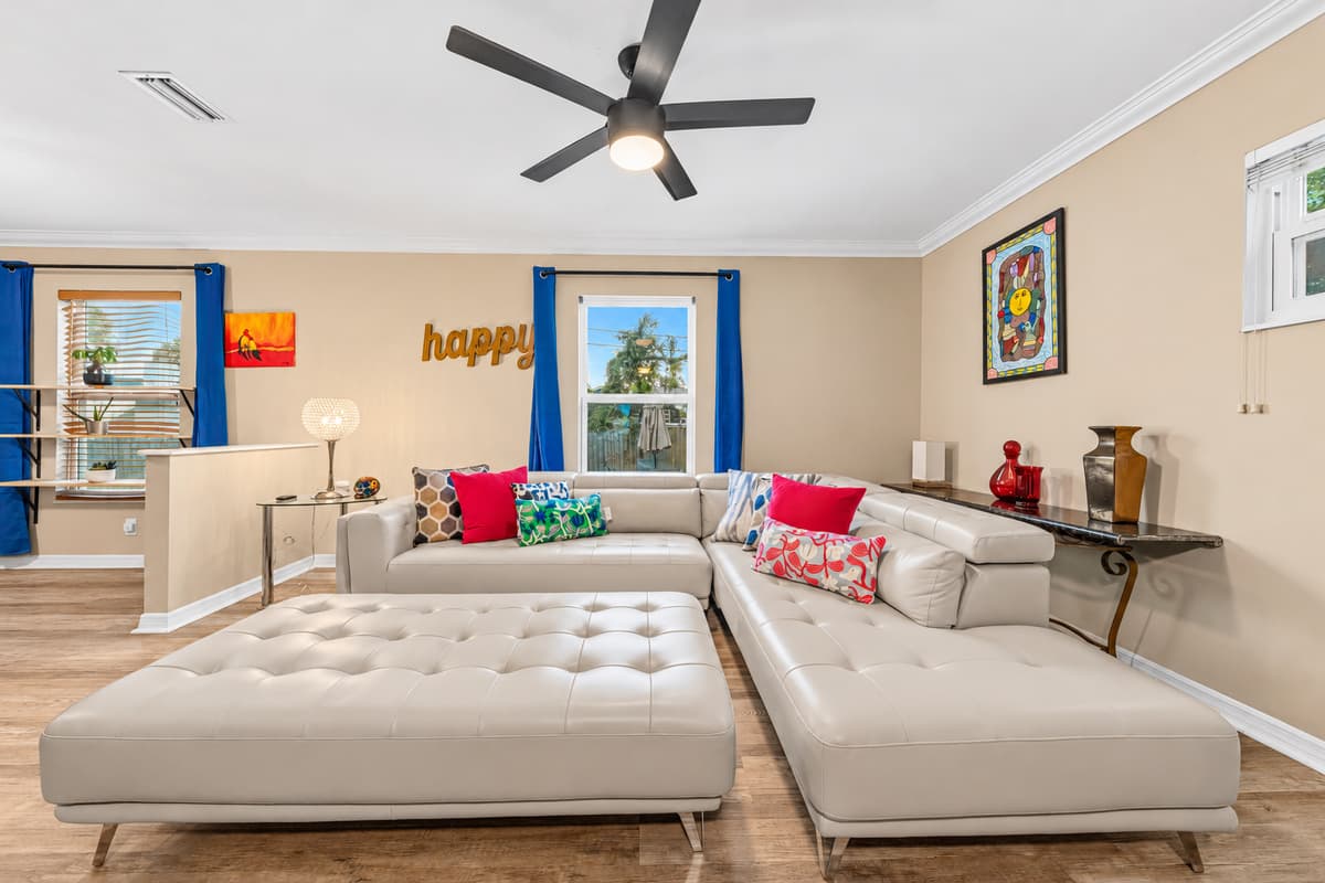 Comfortable living room with plush sectional, large TV, and vibrant accents for a cozy stay.
