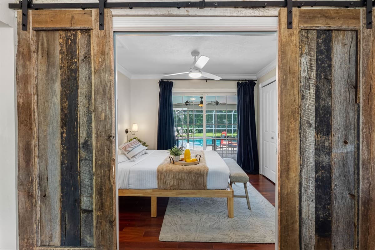 A cozy bedroom with direct backyard and pool views, perfect for morning sunshine.